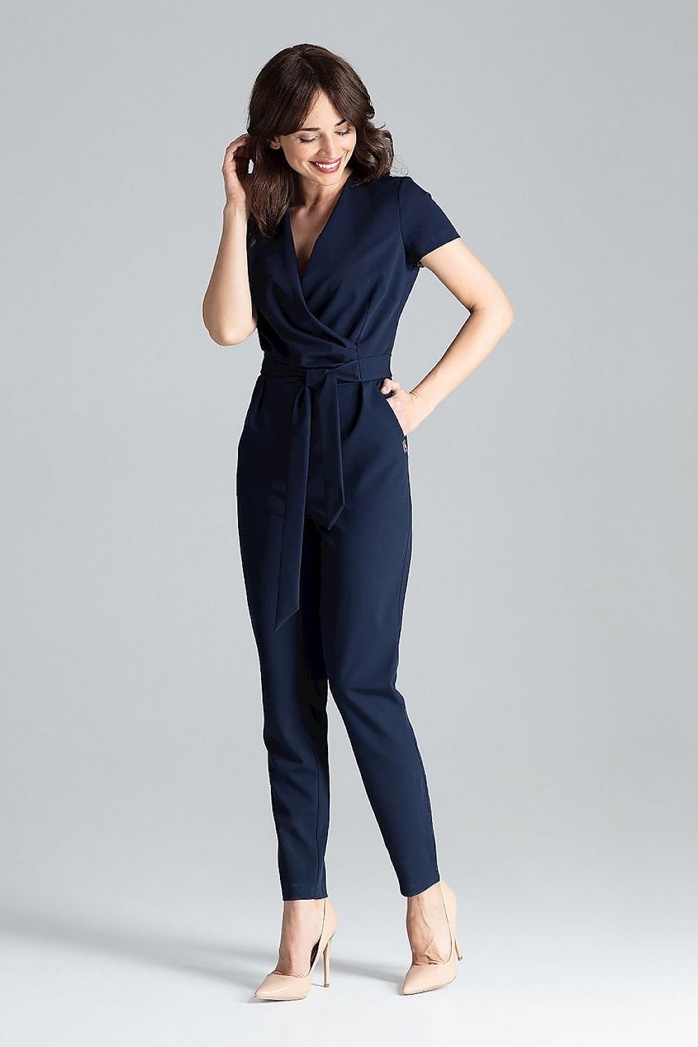 Short-sleeved jumpsuit with loose drape at the waist, tie belt, and long trousers, ideal for a stylish city look.