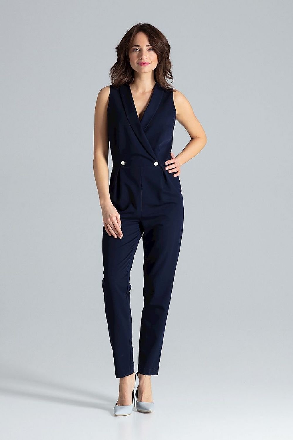 Classic sleeveless jumpsuit with lined narrow lapels, envelope neckline, decorative silver-colored metal snap fasteners, and slanted side pockets.