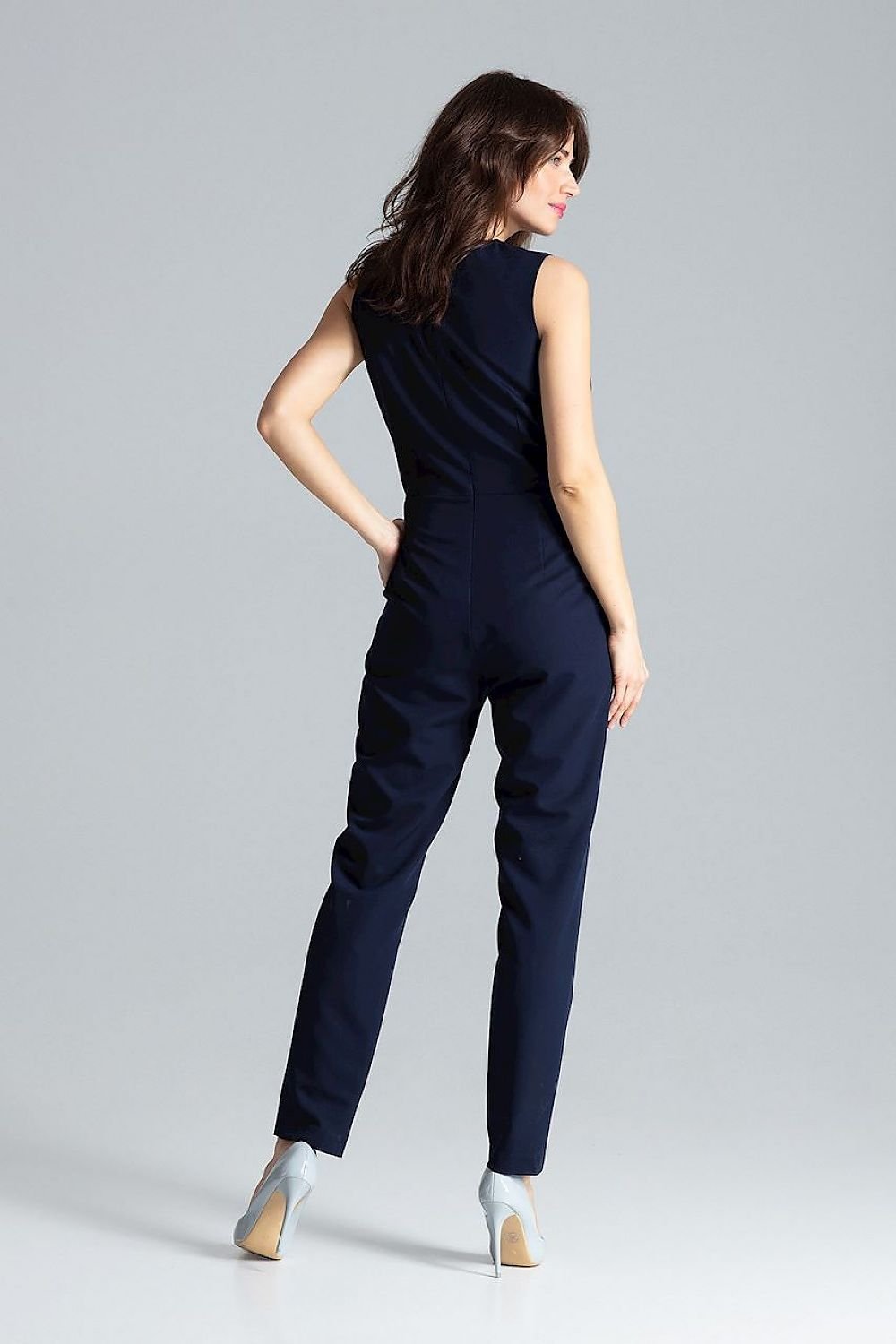 Classic sleeveless jumpsuit with lined narrow lapels, envelope neckline, decorative silver-colored metal snap fasteners, and slanted side pockets.